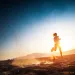 A runner silhouetted against a desert sky and landscape. 