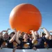 West Virginia University students—wearing T-shirts that say "Preserving Energy with Appalachian Knowledge"—at the 2013 Solar Decathlon at the Orange County Great Park (known for its giant orange balloon).