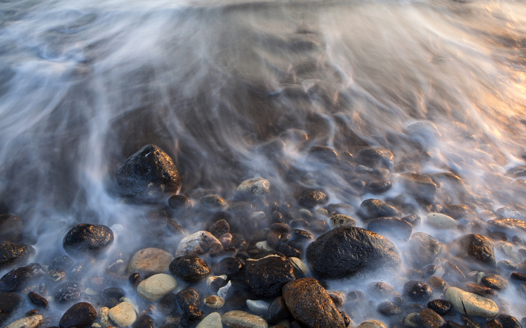 Sunrise illuminates rocks on Santa Cruz Island, part of Channel Islands National Park in California.