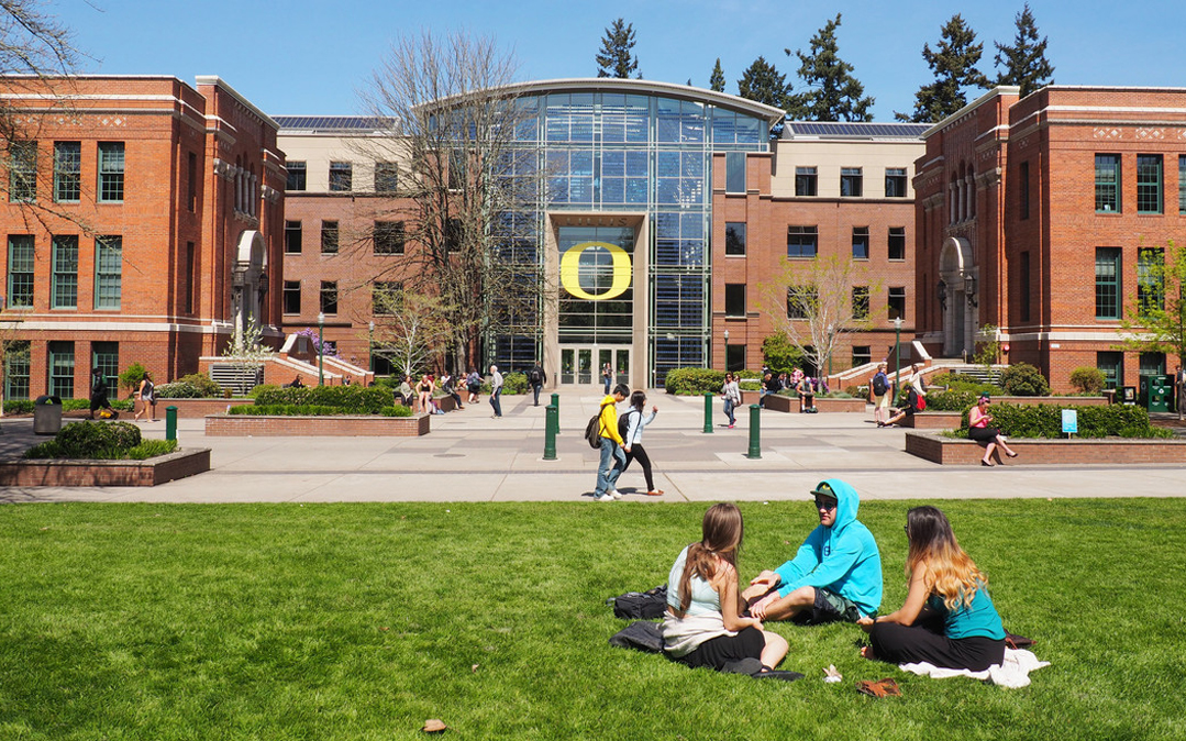 Students enjoy a sunny spring day by one of the University of Oregon's many LEED-certified buildings.