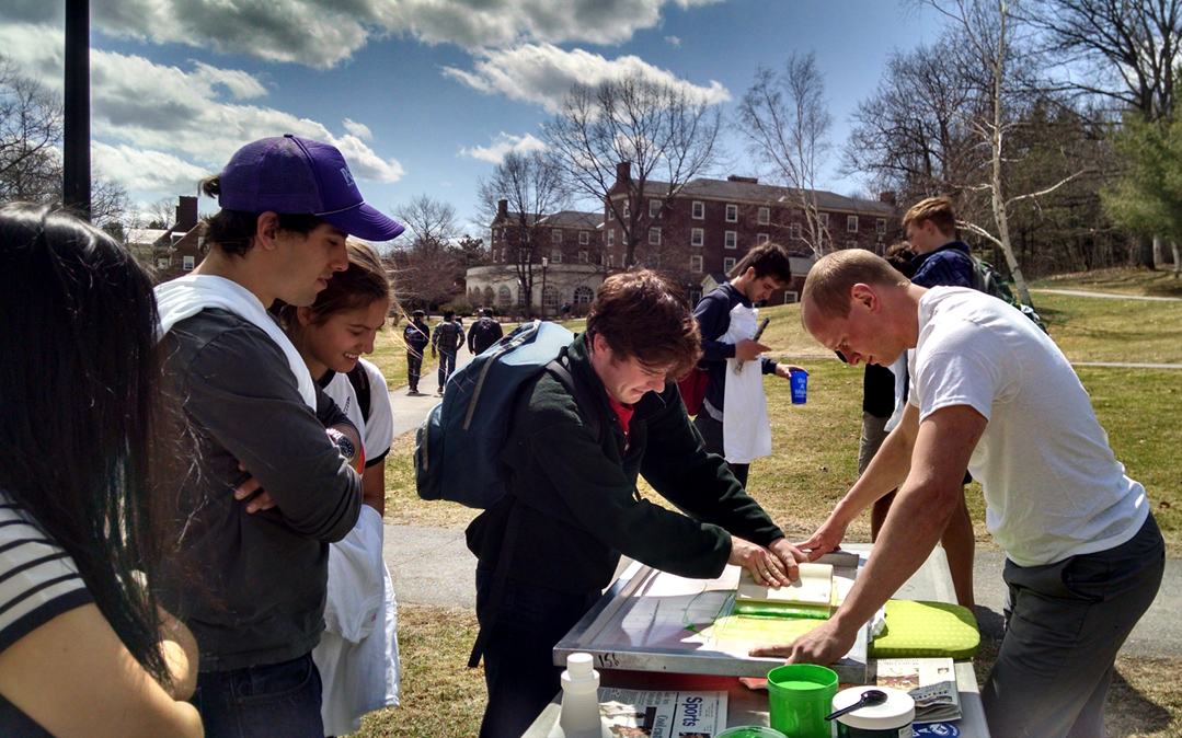 During Earth Week at Colby College, students learn how to screen print T-shirts. The design was created by a student.