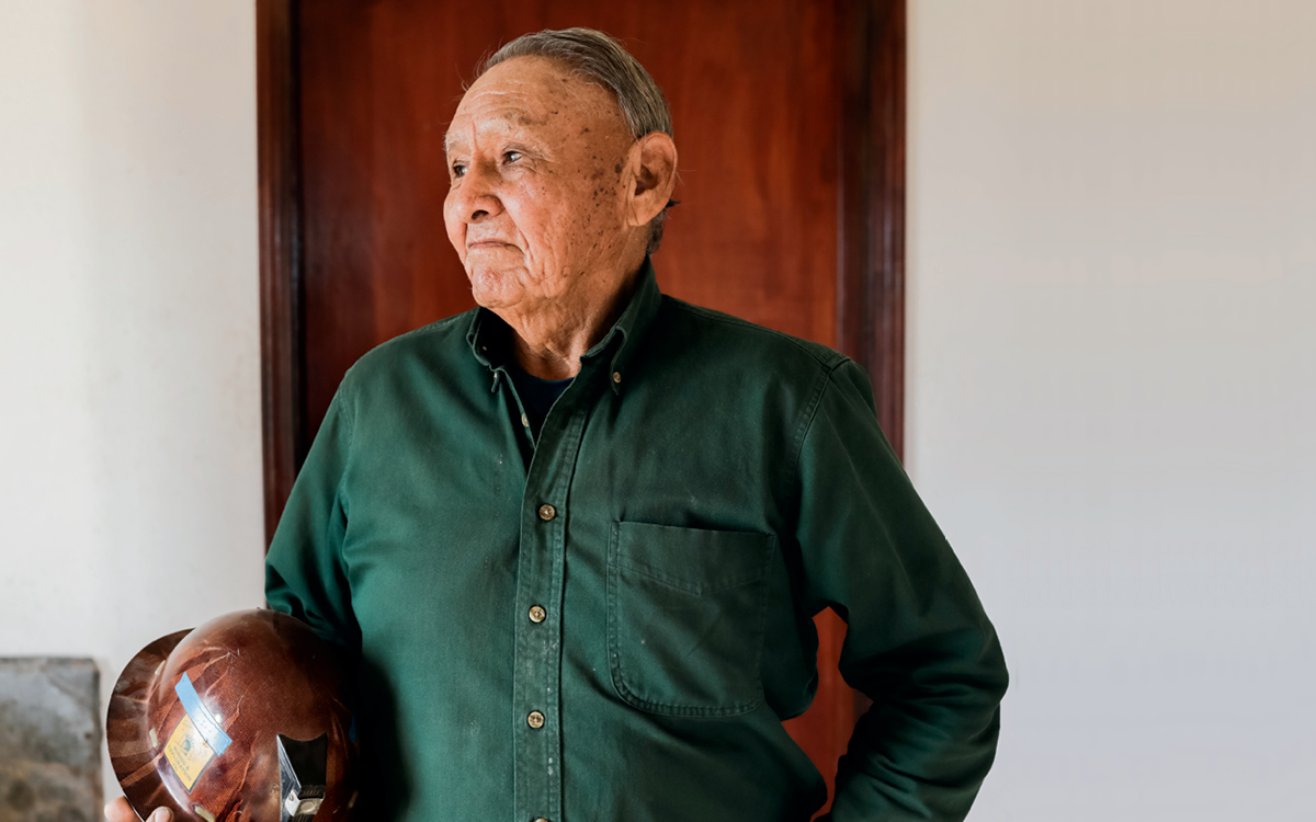 James Smith holds his old mining hat (brown) in his right hand.