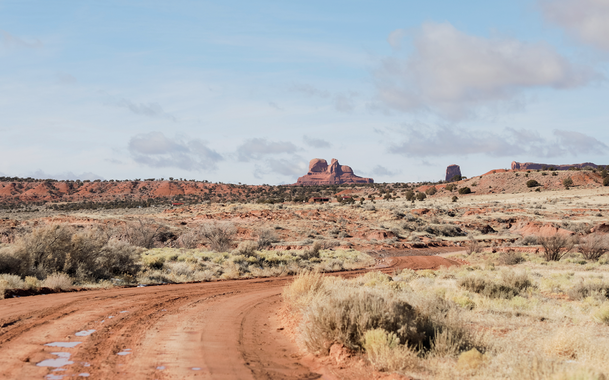 A dirt road curves through desert terrain in Cove, Arizona.