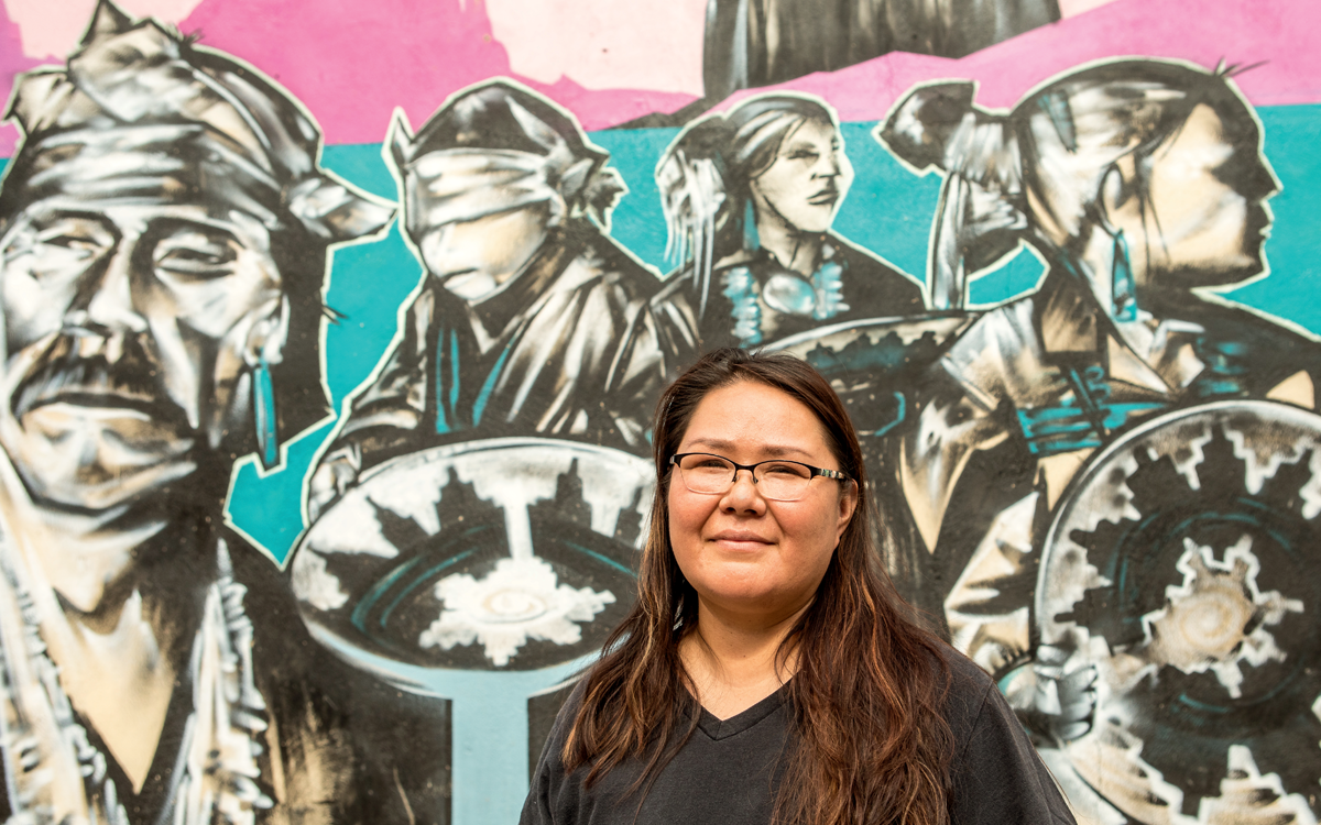 Wendy Atcitty, the New Mexico energy organizer for Diné CARE, in front of the For the People mural, painted by artist Ivan Lee for Farmington’s Art in the Alley project