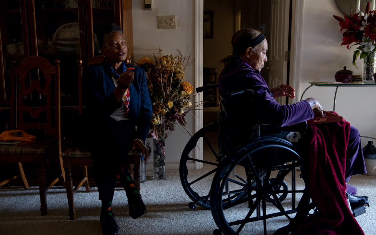 Sally McGee sits in a chair behind Carrie McFadden, who is in a wheelchair.