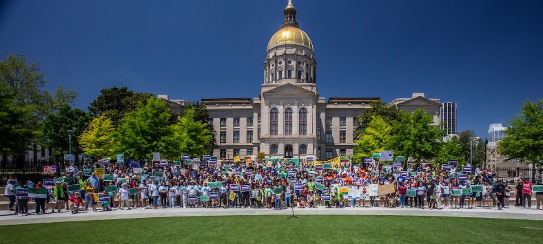 A large group of people gathered in front of the Georgia Capitol to demand climate action. 