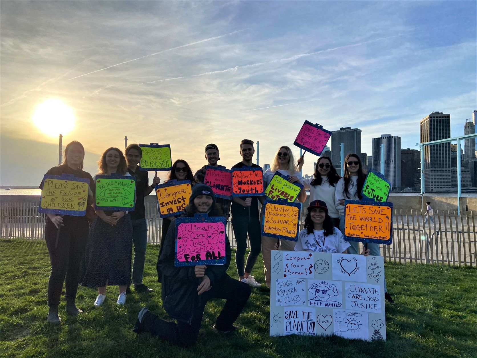 About 12 activists hold signs about green jobs and climate action on Brooklyn's waterfront.