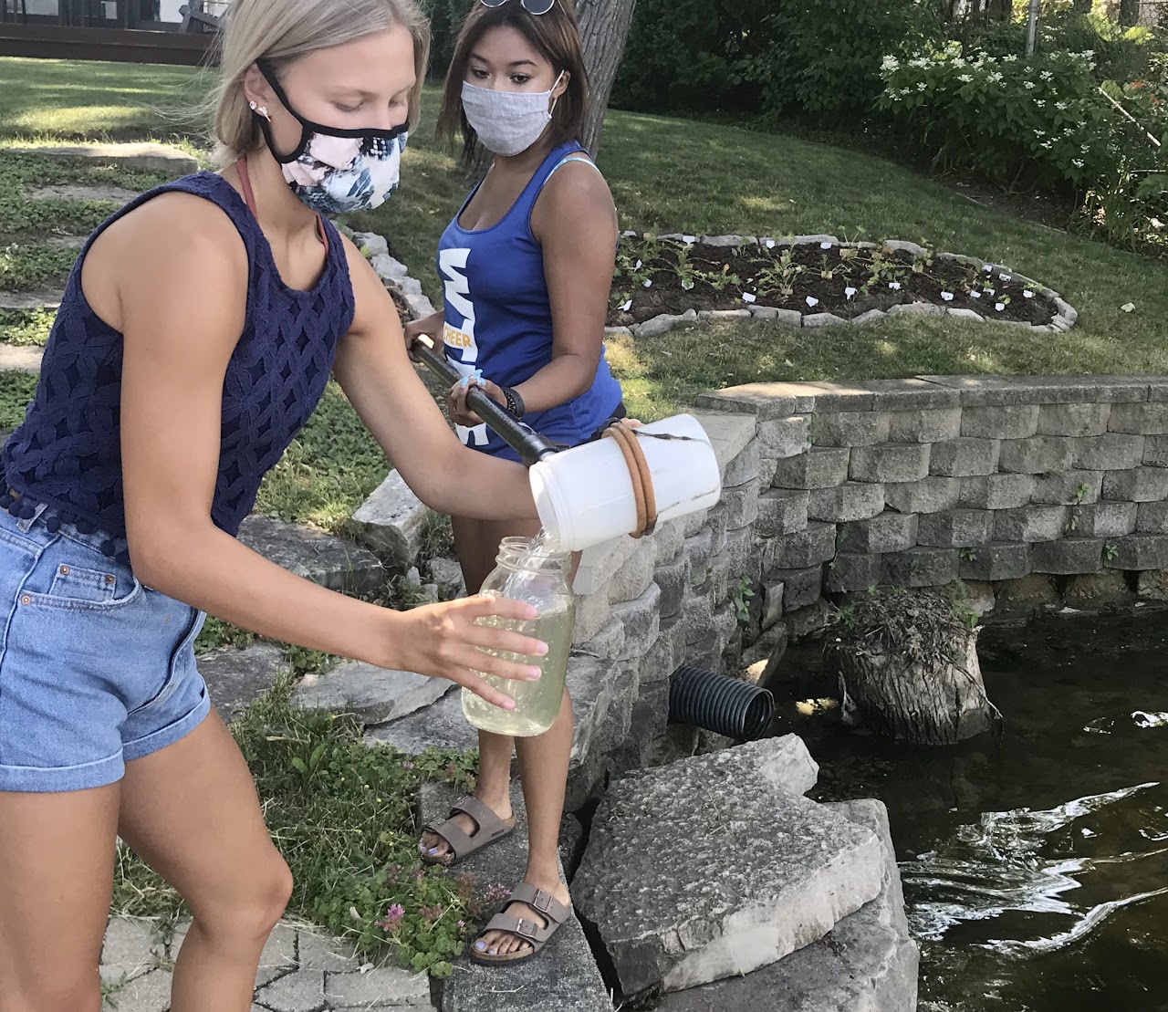 Volunteers Ashley Weihs and Destiny Franklin taking a water sample.