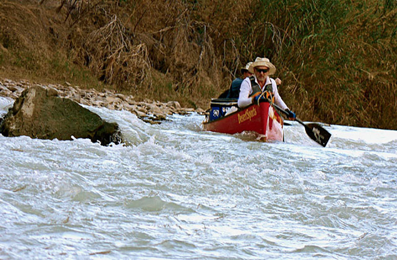 Running a rapid in the lower canyons, where exposed rocks were the main hazards.