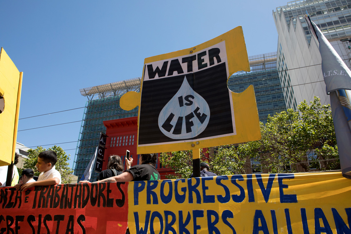 Water is Life sign at May Day March. Photo by Sam Murphy.