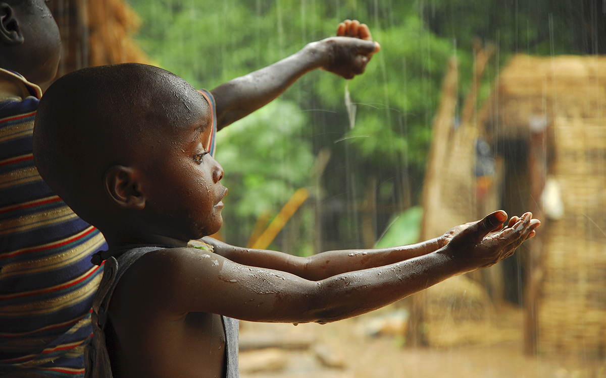 A child and mother catch raindrops in their hands