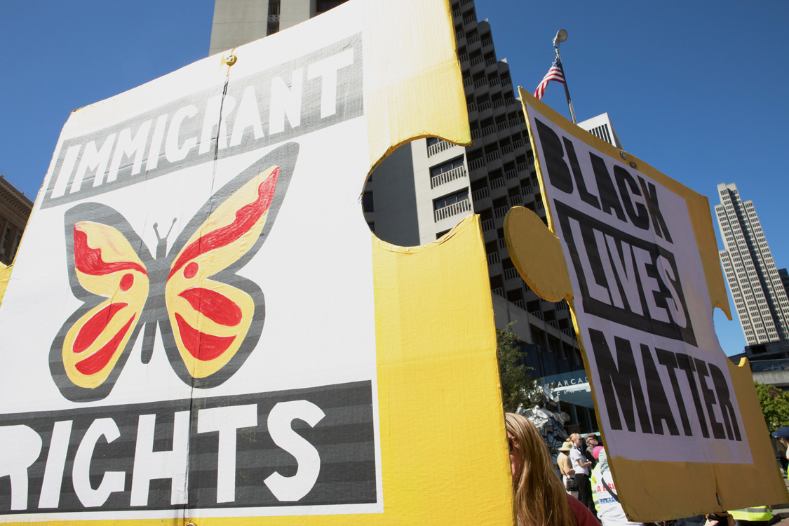 Poster at May Day Protest. Photo by Sam Murphy.