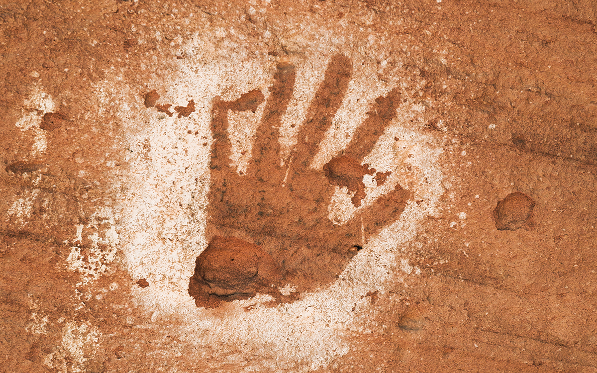 Pictograph of a hand on a redrock wall.