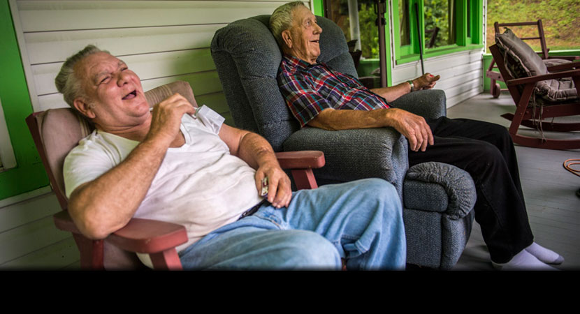 Aleshire shares a laugh with his next-door neighbor Carlos Gore. "I'm too old to move now,'' Aleshire said. ''Why would I want to move?" | Ami Vitale/Panos Pictures