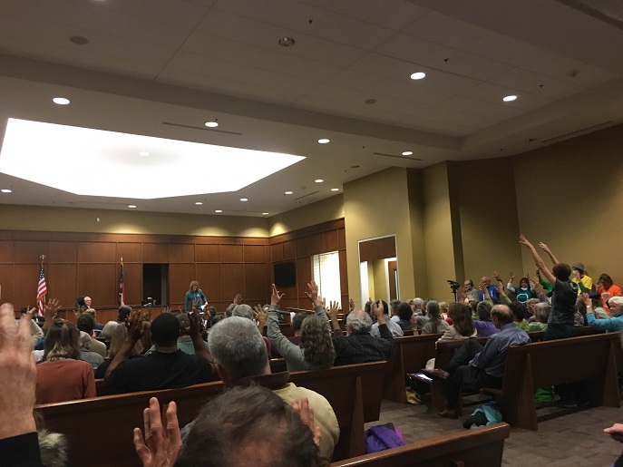 Beyond Coal activists at last Tuesday's Duke Energy hearing wave their fingers in support of the opposition's testimony.