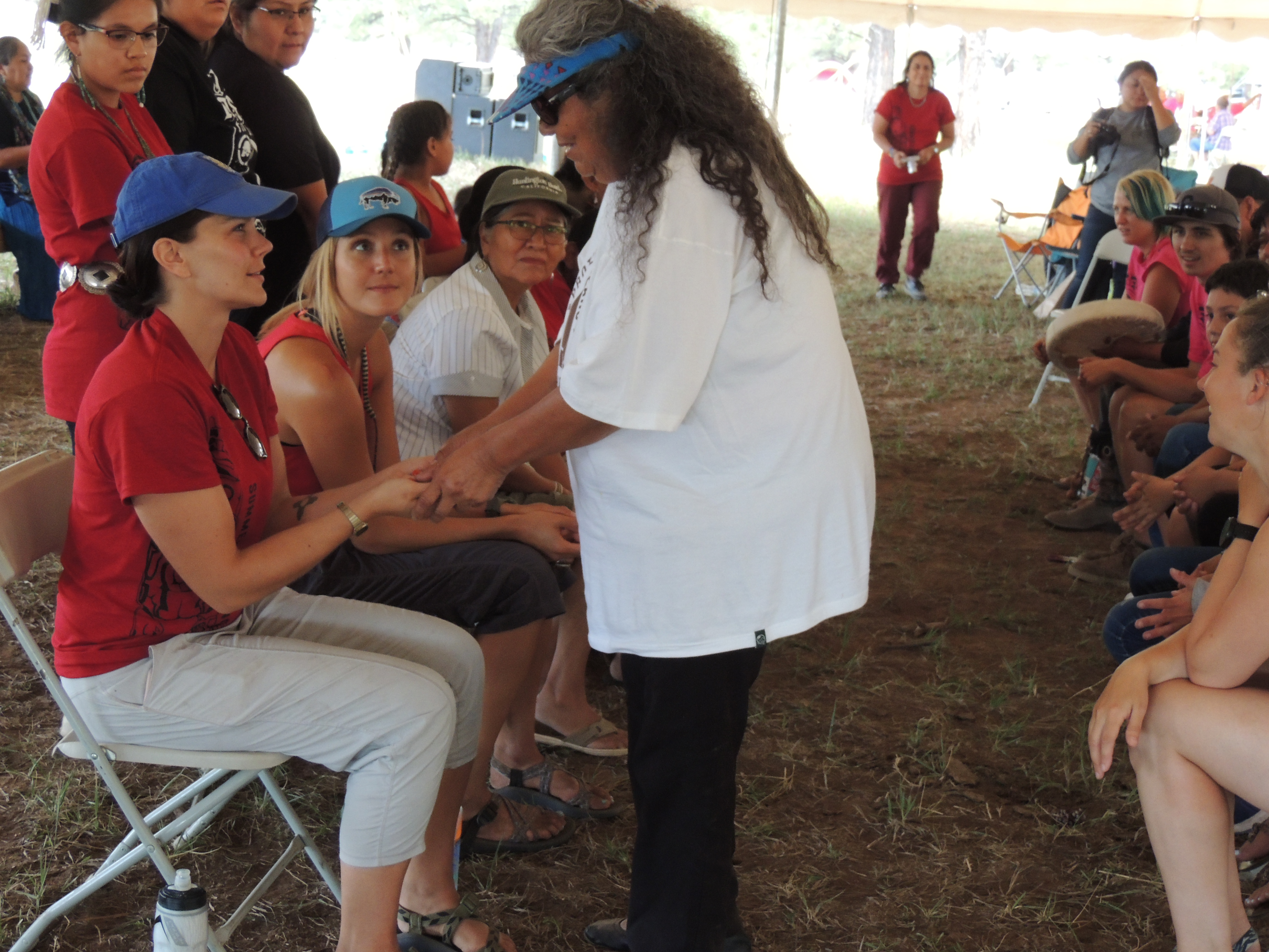 Lena learns traditional hand games from leaders at the Gathering. 