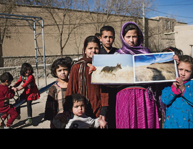 Twelve-year-old Apana Zahor shows photos of a coyote in Yellowstone National Park and a Channel Islands National Park trail. Apana is one of seven children. Her name means 'almond' in Pashto.