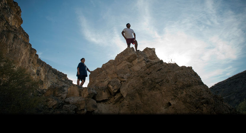 Zayda Hernandez, left, stands on rocks with her cousin Edgar Perez on the Moapa Band of Paiute Reservation.
