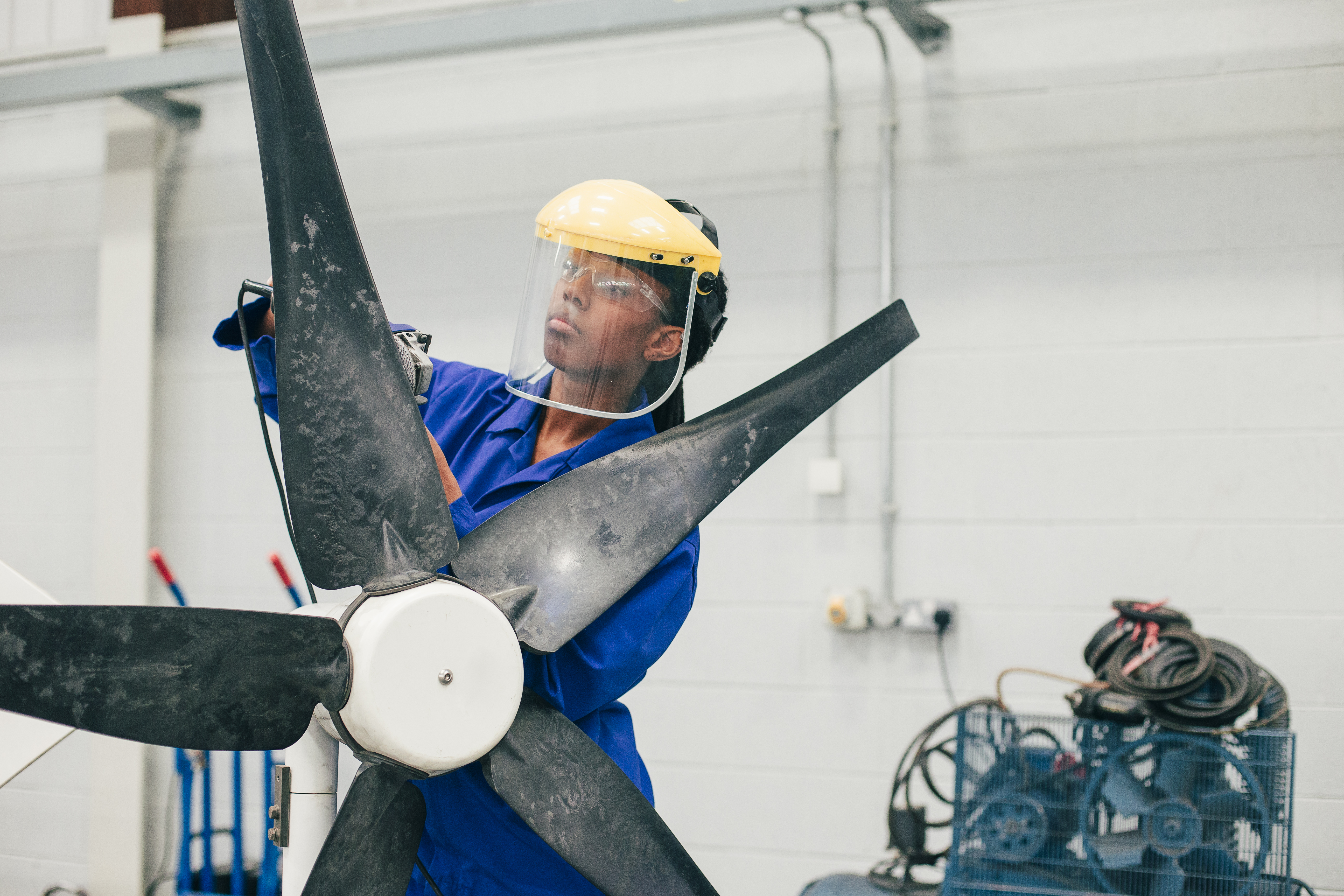 worker with a face mask inspects a wind turbine