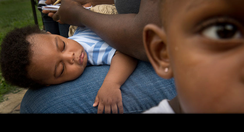 Anthony Johnson sleeps on lap of his mother, Ashley Rivers, as his sister, Ava Rivers, walks away. Both children have asthma.