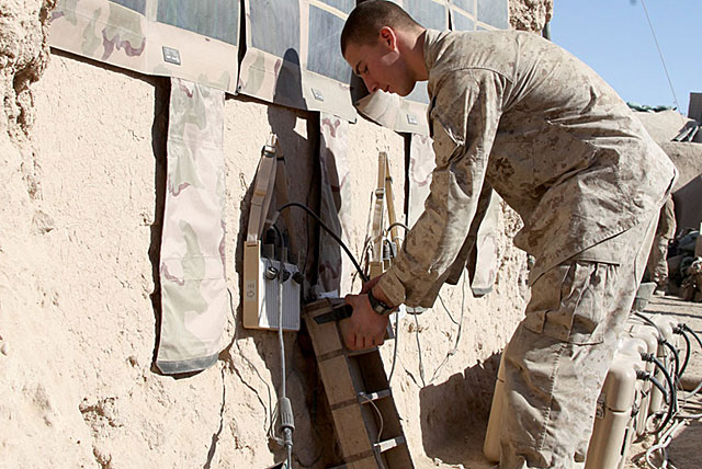 An India Company soldier connects a radio battery to a portable, solar recharging system—part of the Army's ExFOB gear—at Patrol Base Gumbatty, in Afghanistan's Sangin District. | U.S. Marine Corps/Gunnery Sgt. William Price