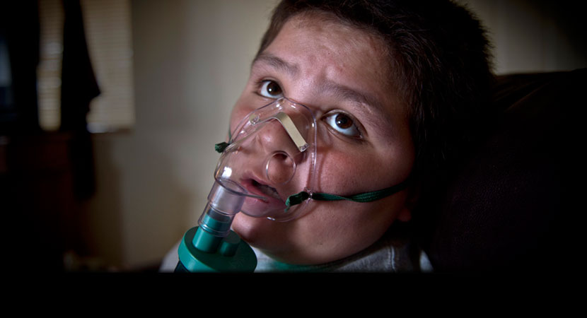 Lane Miller demonstrates using his nebulizer in his home on Nevada's Moapa Band of Paiutes Reservation. "At least once a month he has to use a nebulizer to open up his lungs," his mother, Kami, said. "If I neglect it, he has to go on steroids or it can tu