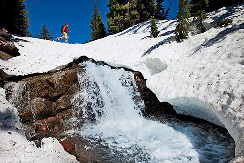 Water running beneath summer snow—a potential death trap.