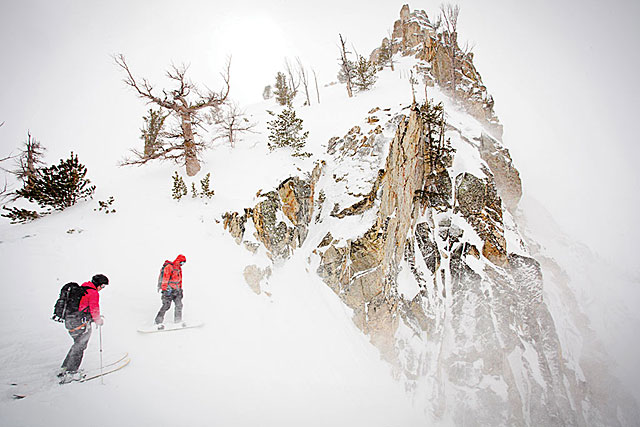 Bracing against 30-mile-per-hour winds, Lindsey Clark and Clark Corey size up the drop on their first serious test, a couloir called There and Back Again.
