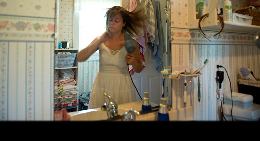 Paula Swearengin blow-dries her hair one last time before having her head shaved to protest mountaintop-removal mining. | Ami Vitale/Panos Pictures
