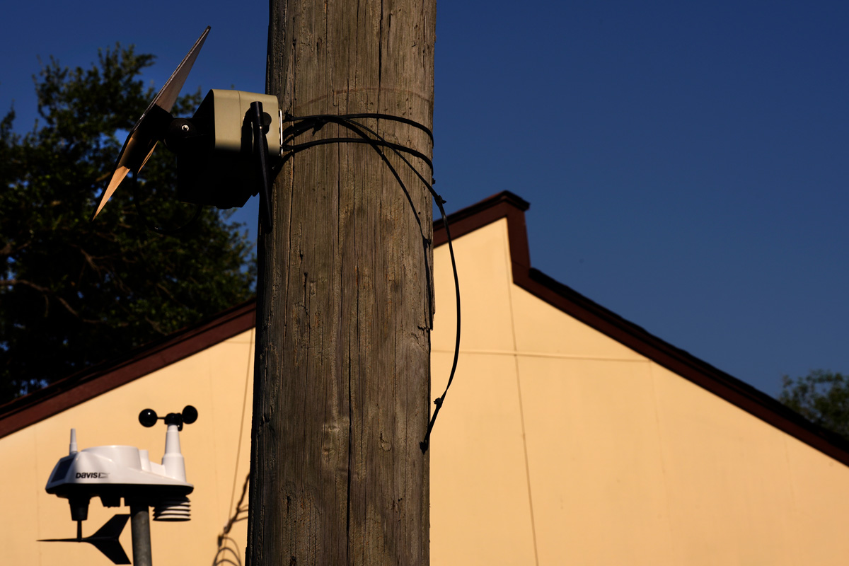 Telephone pole and building side with air quality monitors attached.