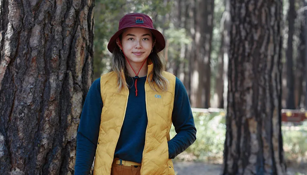 Woman in puffy vest and soft brim magenta outdoor hat